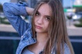 Young beautiful charming stylish European girl, 16 years old, with long brown hair, brown eyes, wearing a denim jacket, street por Royalty Free Stock Photo