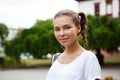 Young beautiful cheerful female student smiling, holding folders outdoors, park background. Royalty Free Stock Photo