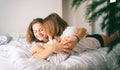 Young beautiful cheerful lesbian couple in love hugging while lying on bed home Royalty Free Stock Photo