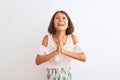 Young beautiful child girl wearing casual dress standing over isolated white background begging and praying with hands together Royalty Free Stock Photo