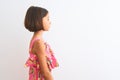 Young beautiful child girl wearing pink floral dress standing over isolated white background looking to side, relax profile pose Royalty Free Stock Photo