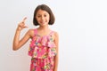 Young beautiful child girl wearing pink floral dress standing over isolated white background smiling and confident gesturing with Royalty Free Stock Photo