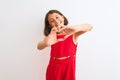 Young beautiful child girl wearing red casual dress standing over isolated white background smiling in love showing heart symbol Royalty Free Stock Photo