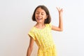 Young beautiful child girl wearing yellow floral dress standing over isolated white background Dancing happy and cheerful, smiling Royalty Free Stock Photo