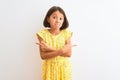 Young beautiful child girl wearing yellow floral dress standing over isolated white background Pointing to both sides with