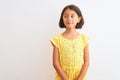 Young beautiful child girl wearing yellow floral dress standing over isolated white background smiling looking to the side and Royalty Free Stock Photo