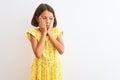 Young beautiful child girl wearing yellow floral dress standing over isolated white background Tired hands covering face, Royalty Free Stock Photo