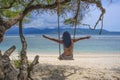 Young beautiful Chinese Asian girl having fun on beach tree swing enjoying happy feeling free in Summer holiday tropical trip