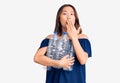 Young beautiful chinese girl holding recycling plastic bottles covering mouth with hand, shocked and afraid for mistake