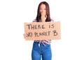 Young beautiful chinese girl holding there is no planet b banner covering mouth with hand, shocked and afraid for mistake Royalty Free Stock Photo