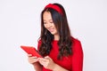 Young beautiful chinese girl holding touchpad looking positive and happy standing and smiling with a confident smile showing teeth Royalty Free Stock Photo