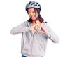 Young beautiful chinese girl wearing bike helmet smiling in love showing heart symbol and shape with hands Royalty Free Stock Photo