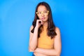 Young beautiful chinese girl wearing casual clothes and glasses serious face thinking about question with hand on chin, thoughtful Royalty Free Stock Photo