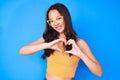 Young beautiful chinese girl wearing casual clothes and glasses smiling in love showing heart symbol and shape with hands Royalty Free Stock Photo