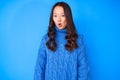 Young beautiful chinese girl wearing casual winter sweater afraid and shocked with surprise expression, fear and excited face Royalty Free Stock Photo