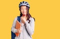 Young beautiful chinese girl wearing student backpack and bike helmet holding book serious face thinking about question with hand Royalty Free Stock Photo