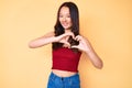 Young beautiful chinese girl wearing summer clothes smiling in love showing heart symbol and shape with hands Royalty Free Stock Photo