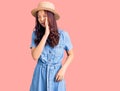 Young beautiful chinese girl wearing summer hat hand on mouth telling secret rumor, whispering malicious talk conversation Royalty Free Stock Photo