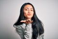 Young beautiful chinese sporty woman wearing sweatshirt over isolated white background looking at the camera blowing a kiss with Royalty Free Stock Photo