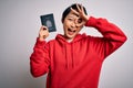 Young beautiful chinese tourist woman on vacation holding canada canadian passport with happy face smiling doing ok sign with hand