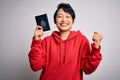 Young beautiful chinese tourist woman on vacation holding canada canadian passport screaming proud and celebrating victory and