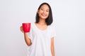 Young beautiful chinese woman drinking cup of coffee over isolated white background with a happy face standing and smiling with a Royalty Free Stock Photo