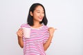 Young beautiful chinese woman drinking cup of coffee over isolated white background pointing and showing with thumb up to the side Royalty Free Stock Photo