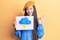 Young beautiful chinese woman holdig cloud and thunder draw doing ok sign with fingers, smiling friendly gesturing excellent