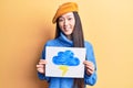 Young beautiful chinese woman holdig cloud and thunder draw looking positive and happy standing and smiling with a confident smile