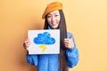 Young beautiful chinese woman holdig cloud and thunder draw smiling happy and positive, thumb up doing excellent and approval sign