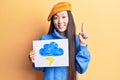 Young beautiful chinese woman holdig cloud and thunder draw smiling with an idea or question pointing finger with happy face,