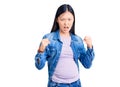 Young beautiful chinese woman pregnant expecting baby angry and mad raising fists frustrated and furious while shouting with anger Royalty Free Stock Photo