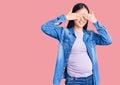 Young beautiful chinese woman pregnant expecting baby covering eyes with hands smiling cheerful and funny