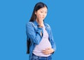Young beautiful chinese woman pregnant expecting baby thinking looking tired and bored with depression problems with crossed arms