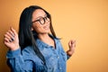 Young beautiful chinese woman wearing casual denim shirt over isolated yellow background Dancing happy and cheerful, smiling Royalty Free Stock Photo