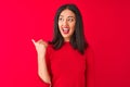 Young beautiful chinese woman wearing casual dress standing over isolated red background smiling with happy face looking and Royalty Free Stock Photo