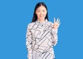 Young beautiful chinese woman wearing casual shirt showing and pointing up with fingers number four while smiling confident and