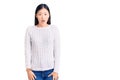 Young beautiful chinese woman wearing casual sweater afraid and shocked with surprise and amazed expression, fear and excited face Royalty Free Stock Photo