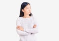 Young beautiful chinese woman wearing casual sweater looking to the side with arms crossed convinced and confident Royalty Free Stock Photo