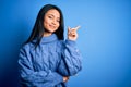 Young beautiful chinese woman wearing casual sweater over isolated blue background with a big smile on face, pointing with hand Royalty Free Stock Photo