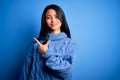 Young beautiful chinese woman wearing casual sweater over isolated blue background cheerful with a smile of face pointing with Royalty Free Stock Photo