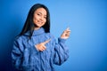 Young beautiful chinese woman wearing casual sweater over isolated blue background smiling and looking at the camera pointing with Royalty Free Stock Photo