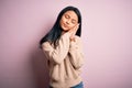 Young beautiful chinese woman wearing casual sweater over isolated pink background sleeping tired dreaming and posing with hands Royalty Free Stock Photo