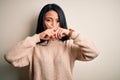 Young beautiful chinese woman wearing casual sweater over isolated white background Rejection expression crossing fingers doing Royalty Free Stock Photo