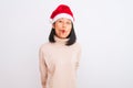 Young beautiful chinese woman wearing Christmas Santa hat over isolated white background making fish face with lips, crazy and Royalty Free Stock Photo