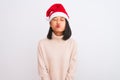 Young beautiful chinese woman wearing Christmas Santa hat over isolated white background puffing cheeks with funny face Royalty Free Stock Photo