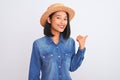 Young beautiful chinese woman wearing denim shirt and hat over isolated white background doing happy thumbs up gesture with hand Royalty Free Stock Photo