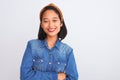 Young beautiful chinese woman wearing denim shirt standing over isolated white background happy face smiling with crossed arms Royalty Free Stock Photo