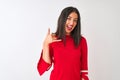 Young beautiful chinese woman wearing red dress standing over isolated white background smiling doing phone gesture with hand and Royalty Free Stock Photo