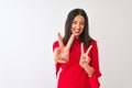 Young beautiful chinese woman wearing red dress standing over isolated white background smiling looking to the camera showing Royalty Free Stock Photo